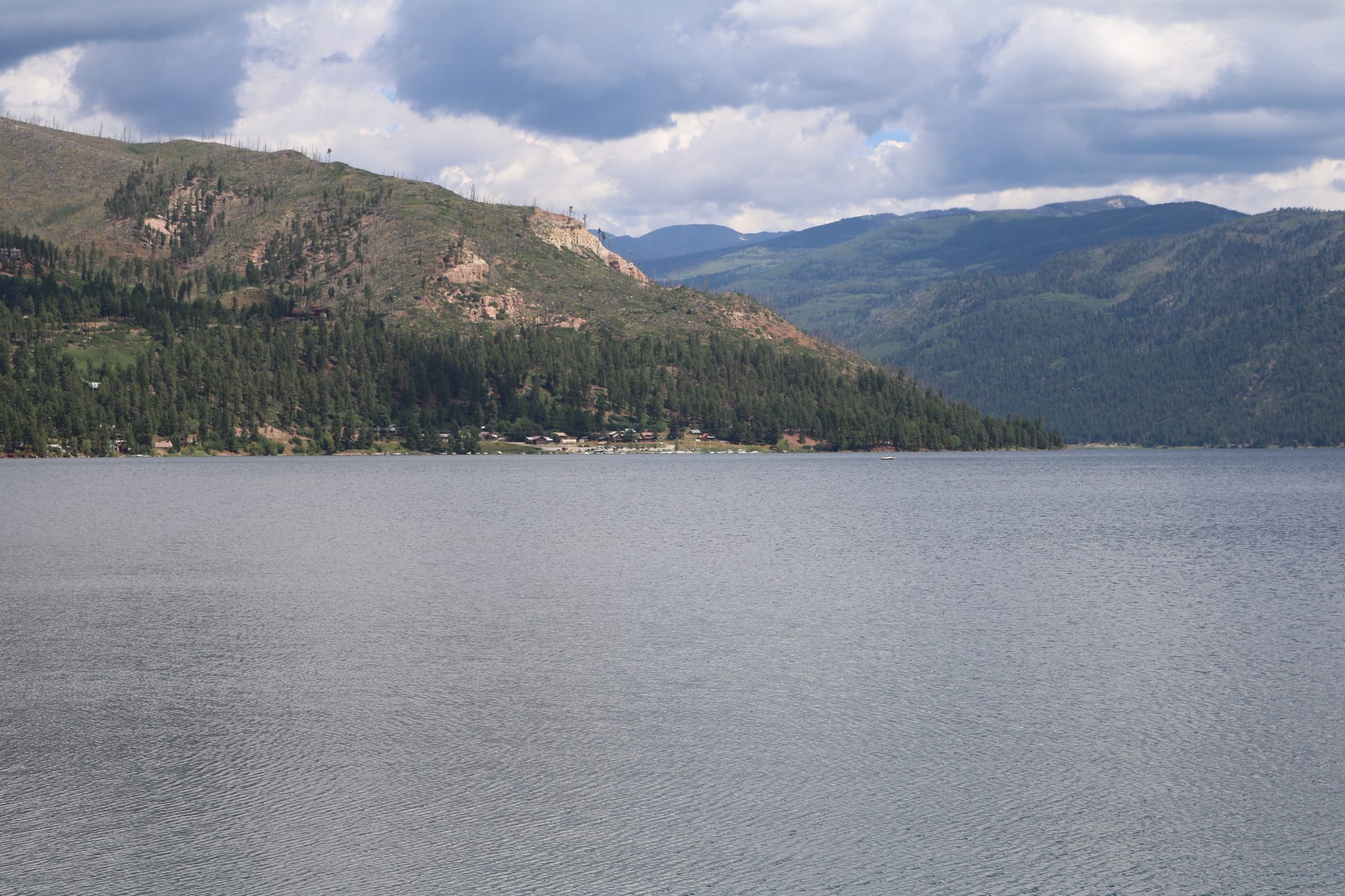 Vallecito Reservoir seen from the dam, with forested mountains rising from the far shore
